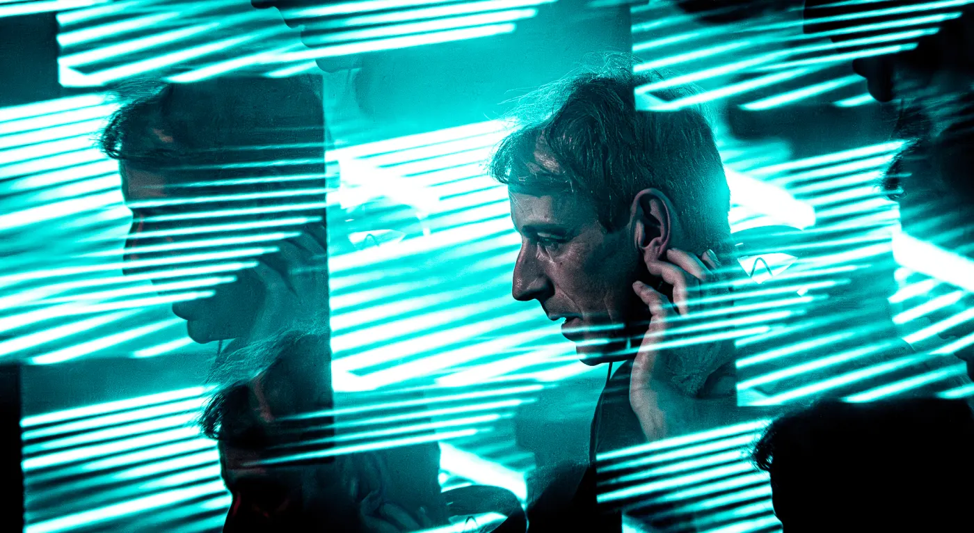 DJ in profile under cyan laser light